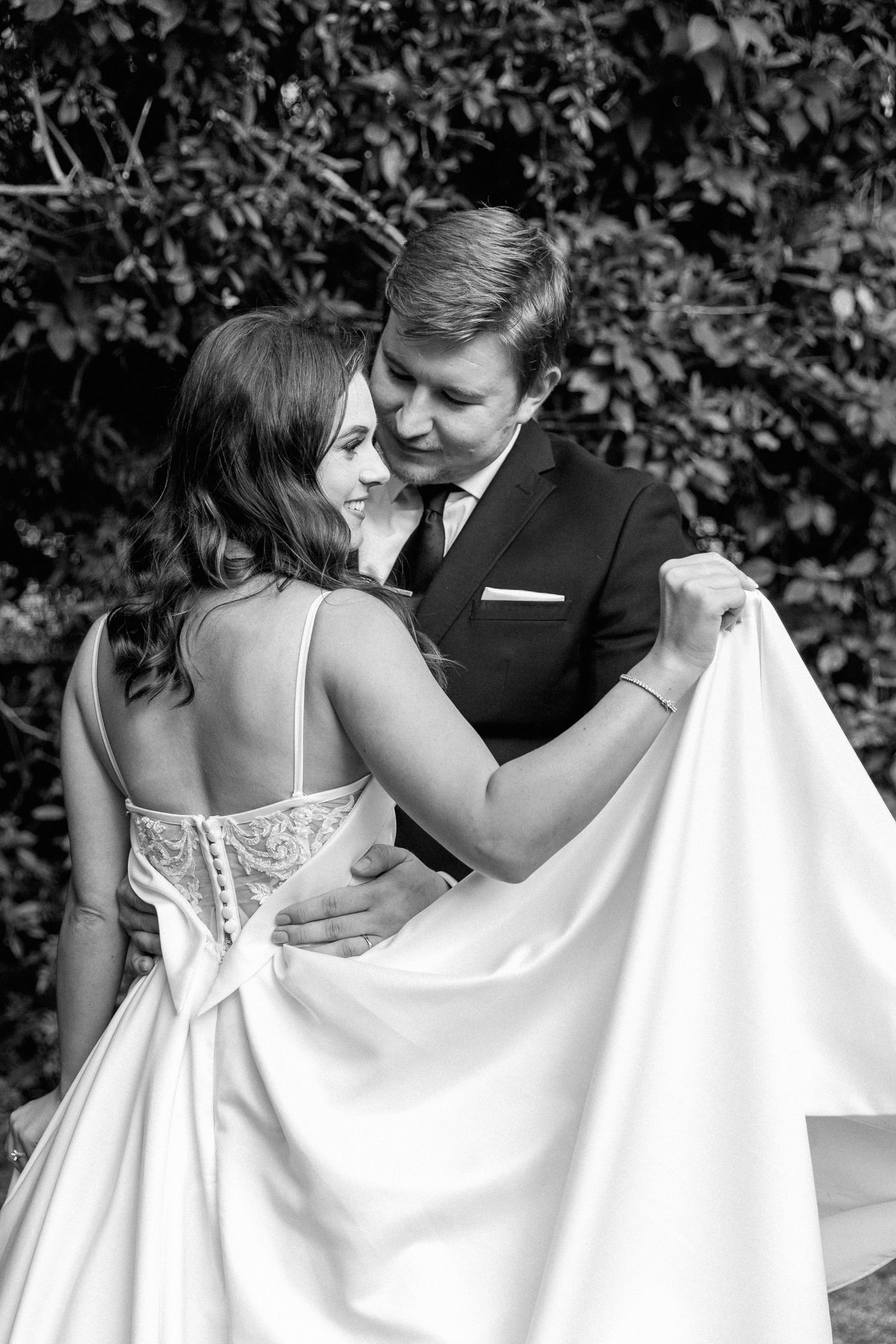 Details of a bride's wedding dress shown off at their Pretoria wedding while the groom holds her.