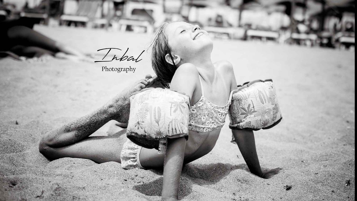 Girl having fun exercising on the sand, trying to touch her head with her feet in a summer photo session.