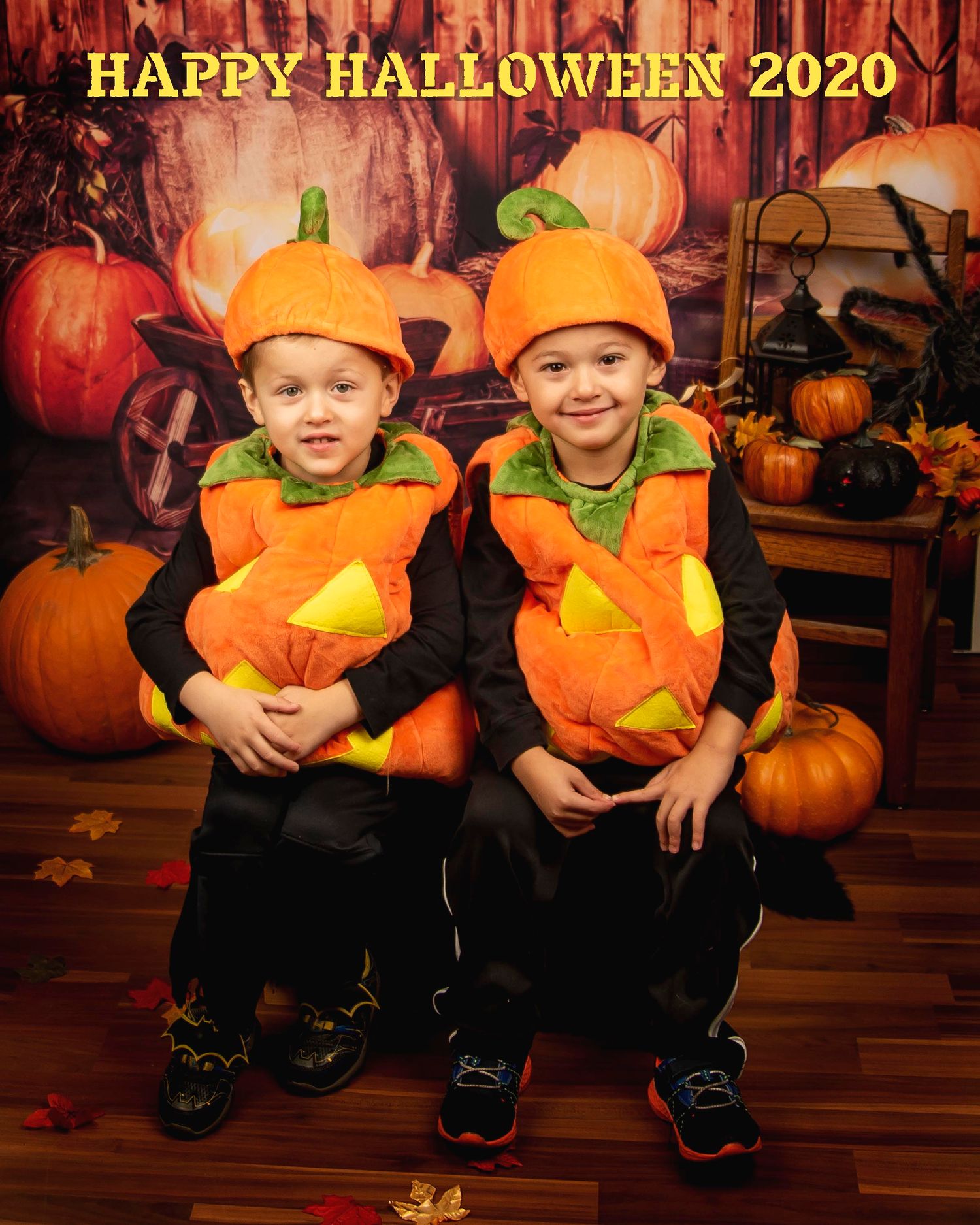 Two matching pumpkin costumes pose together for Halloween 2020 portrait.