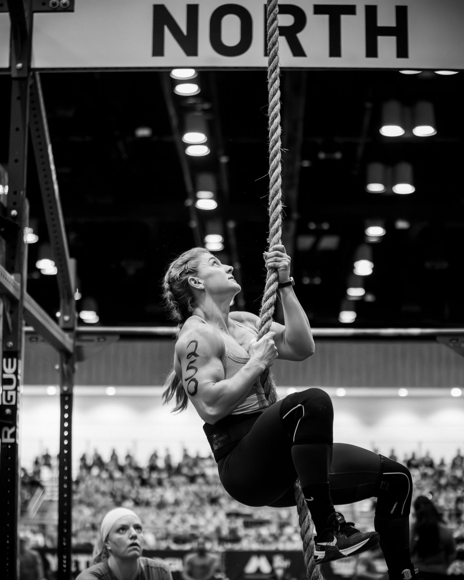 Athlete performing rope climb exercise at North division CrossFit competition.