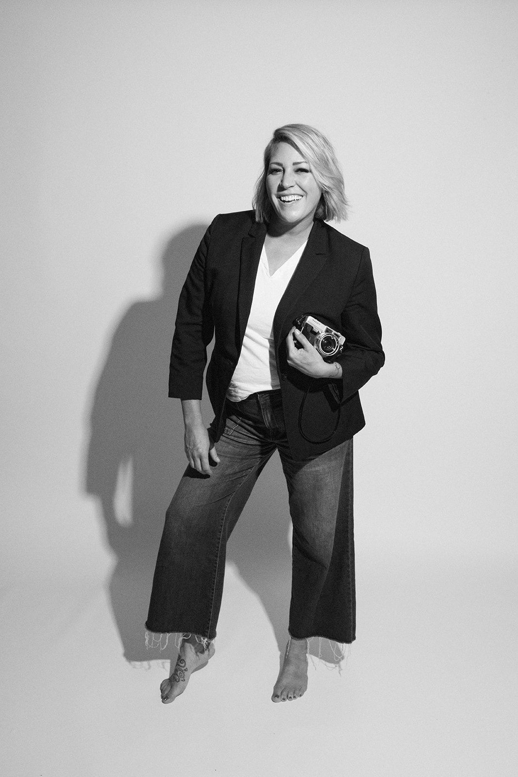 Casual studio portraits featuring relaxed poses in black blazer and white shirt.