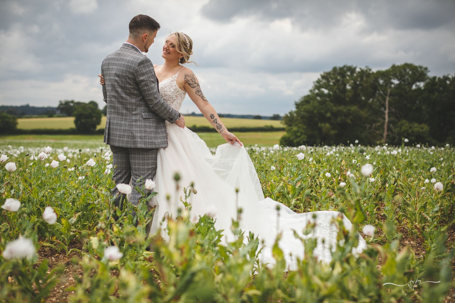 Moments alone for bride and groom in white poppy field, beautiful wedding photography.