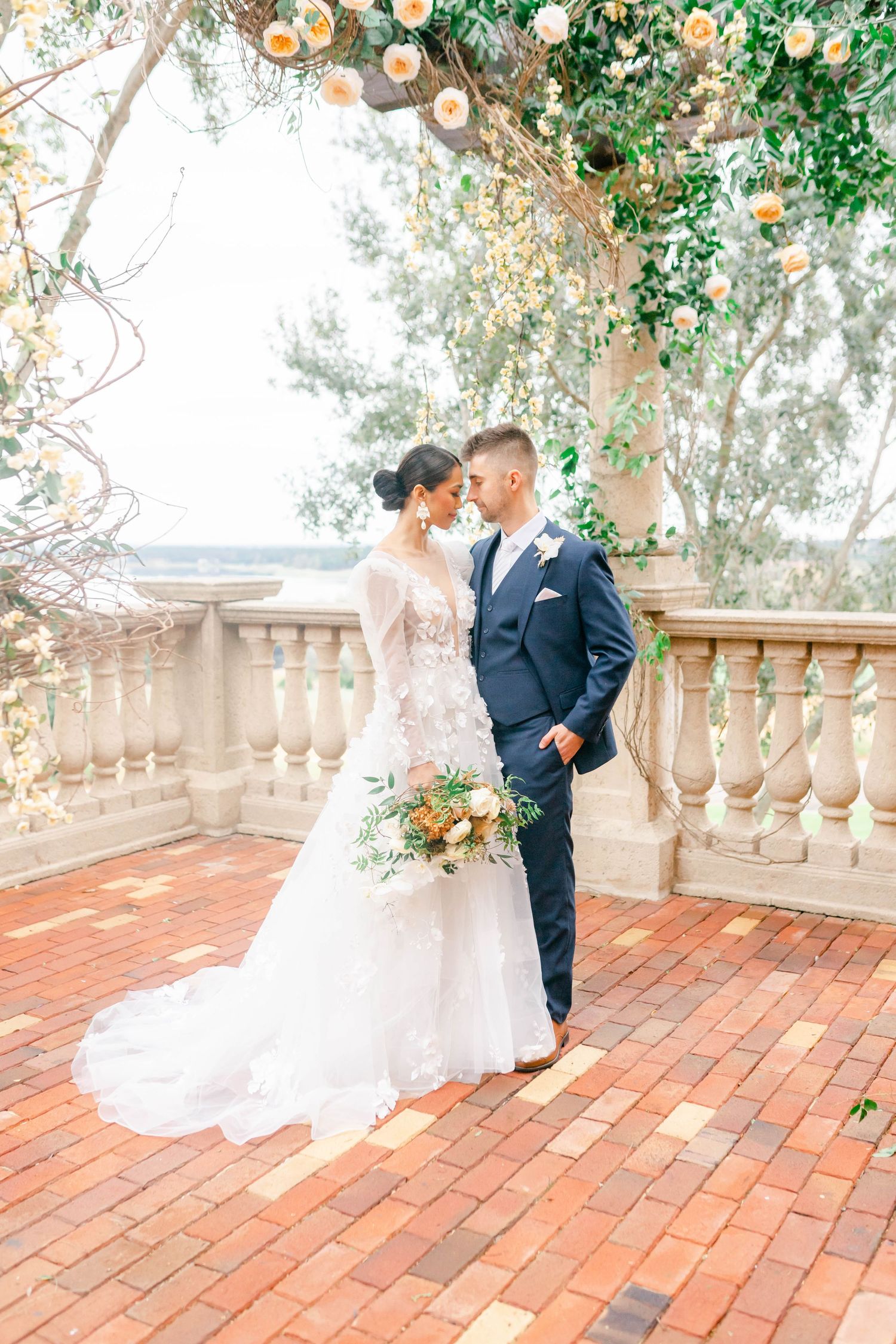 A bride and groom embrace and smile at each other on their wedding day.