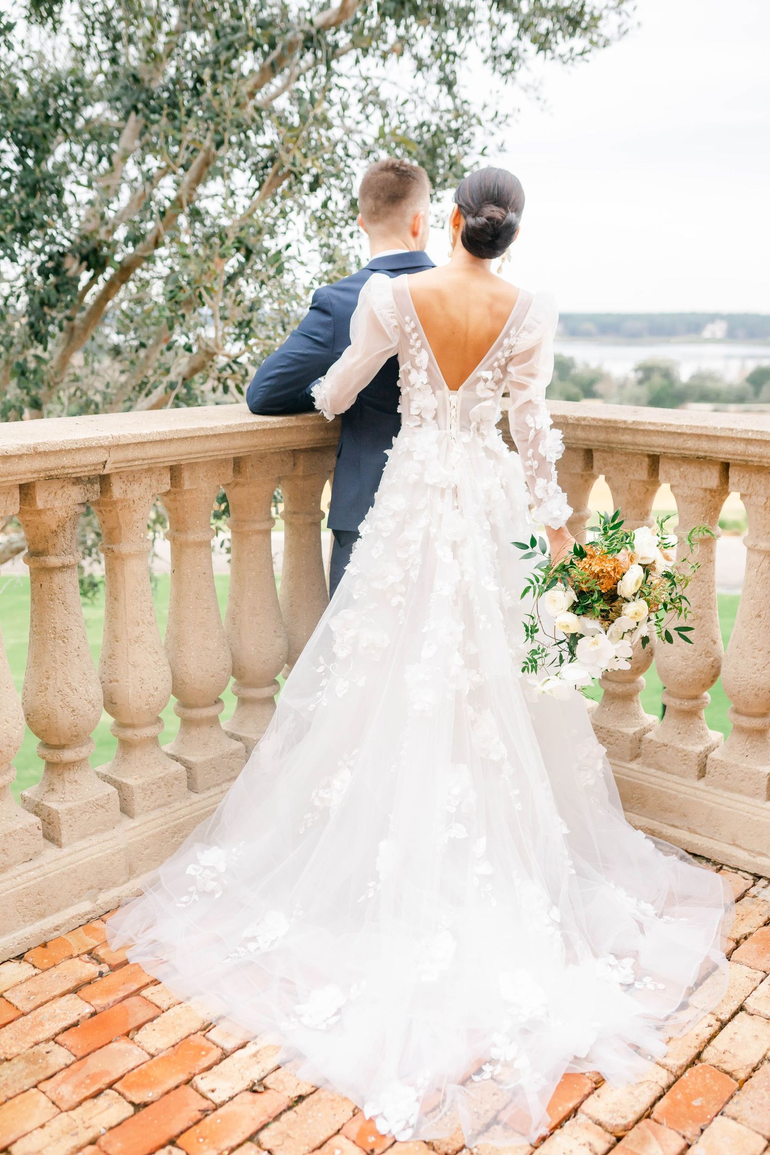 A bride and groom embrace and smile at each other on their wedding day.