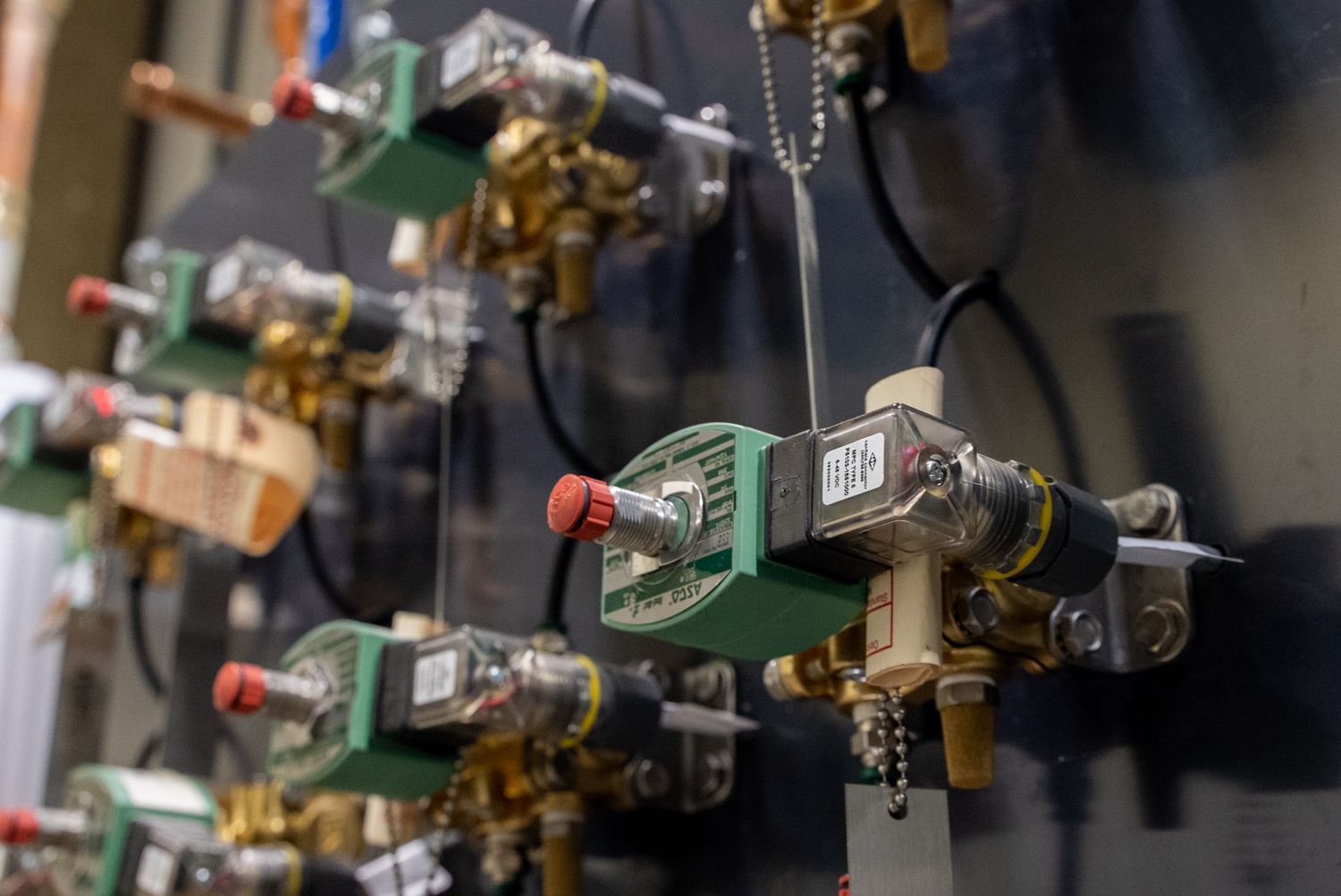 Close-up of industrial gas regulators and valves mounted in a row.