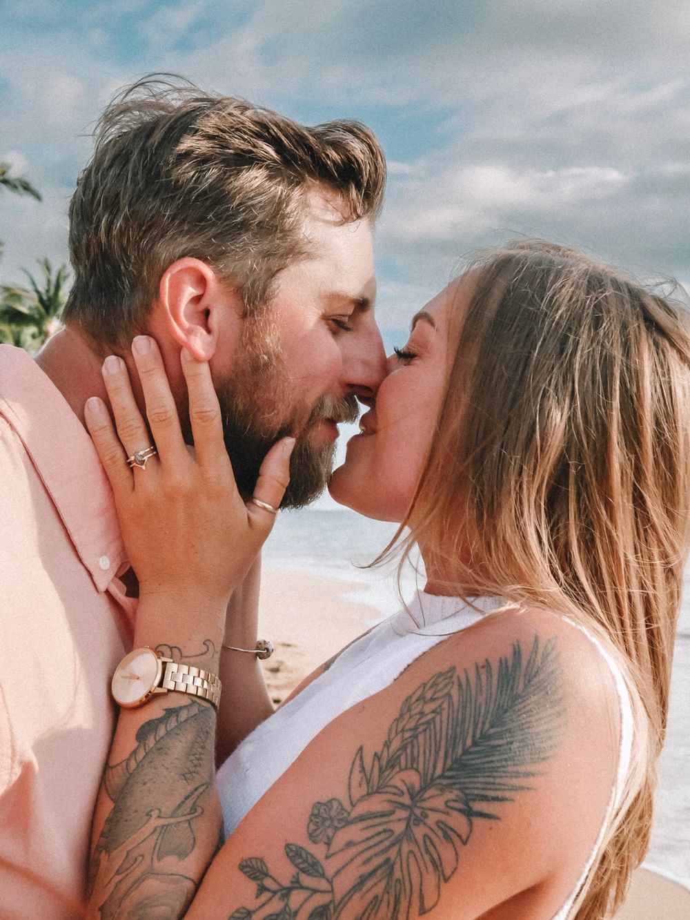 Close-up shots of a couple sharing romantic kisses on a tropical beach with palm trees.