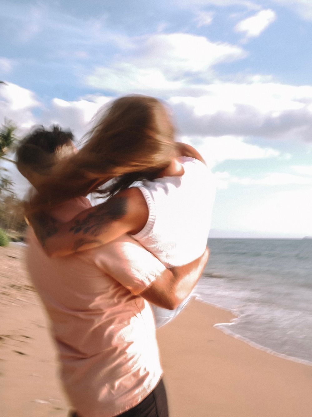 Romantic spinning motion captured on a sunny beach with ocean waves.