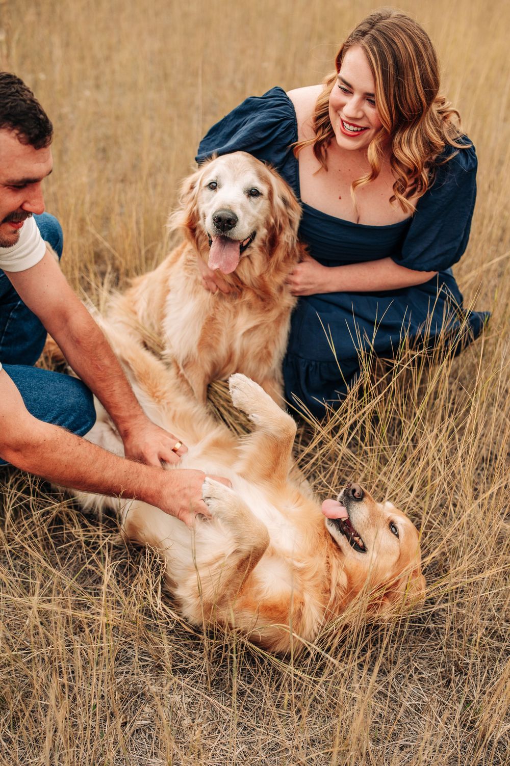 couple playing with their dogs in a field