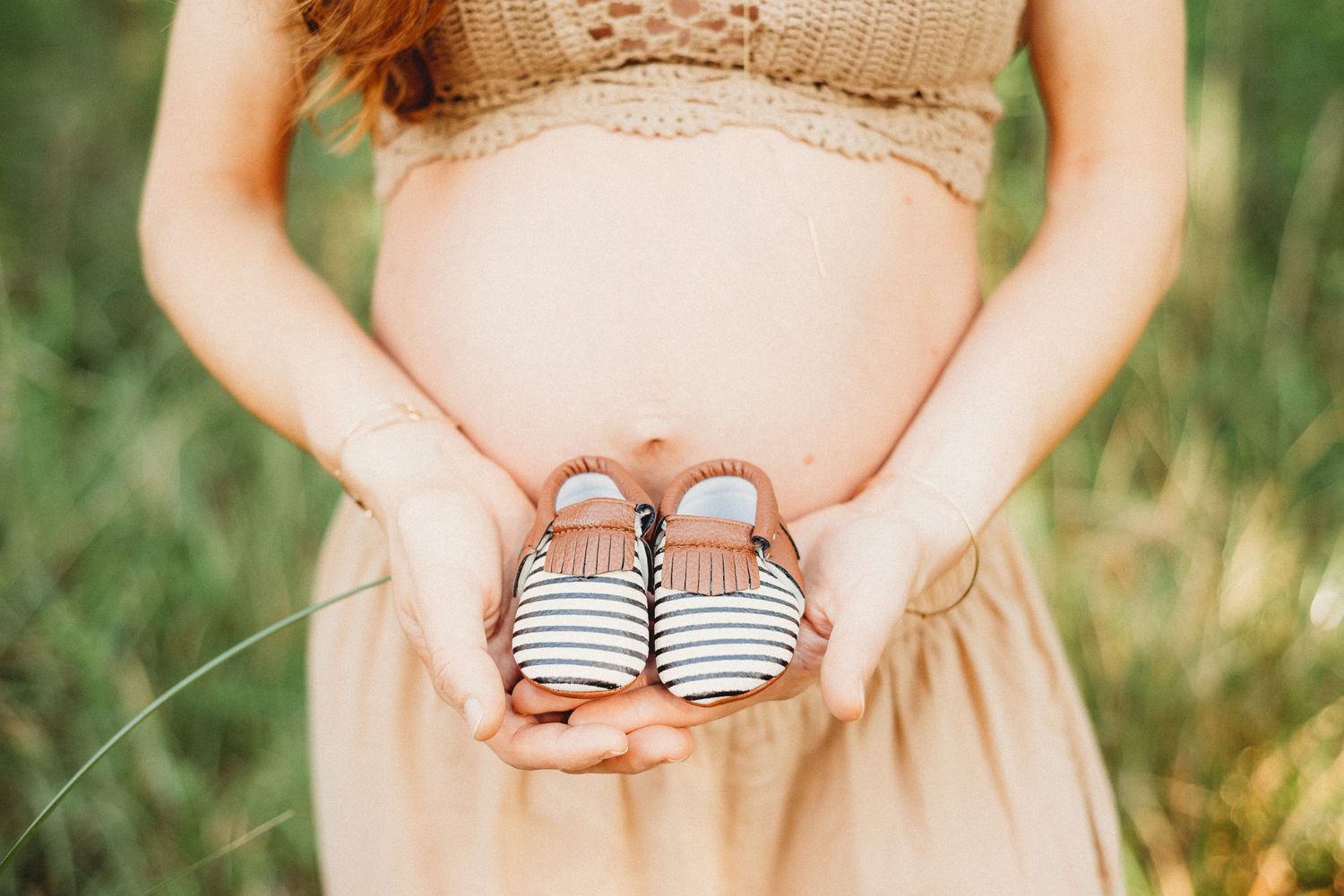 pregnant mother holder her future baby's shoes