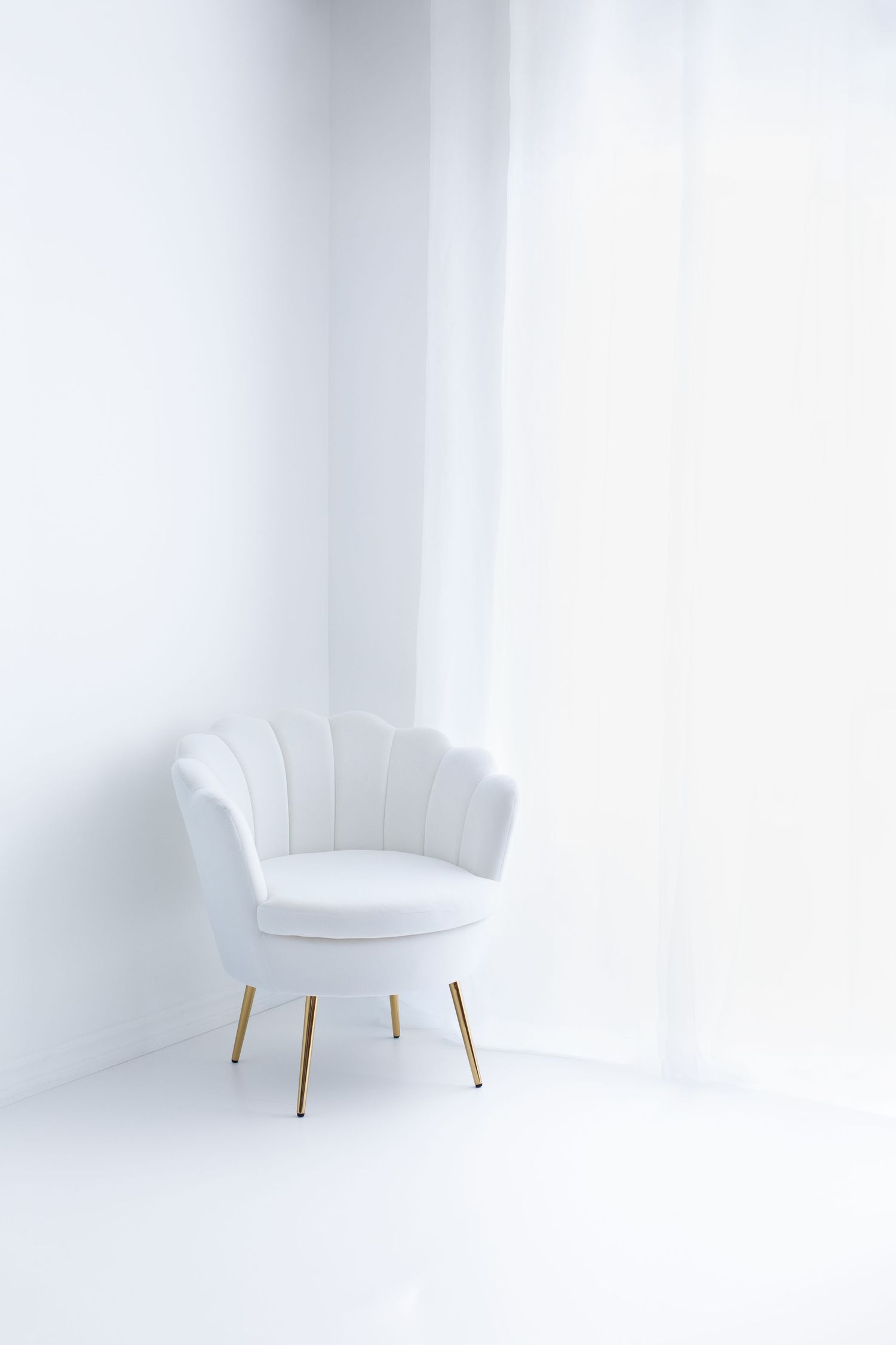 White Photography Studio with a white shell chair in the corner