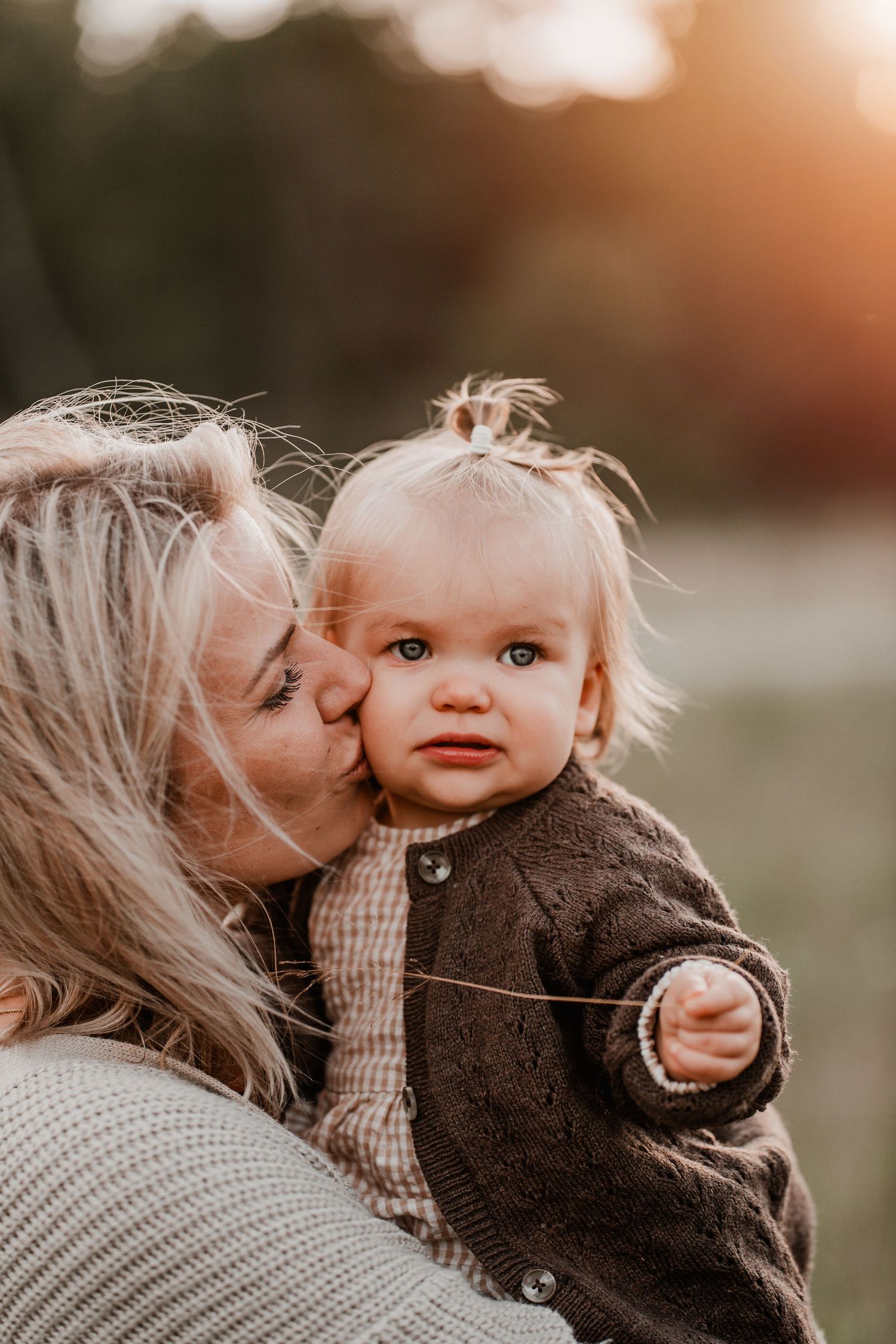 Mamma pussar sin dotter på kinden