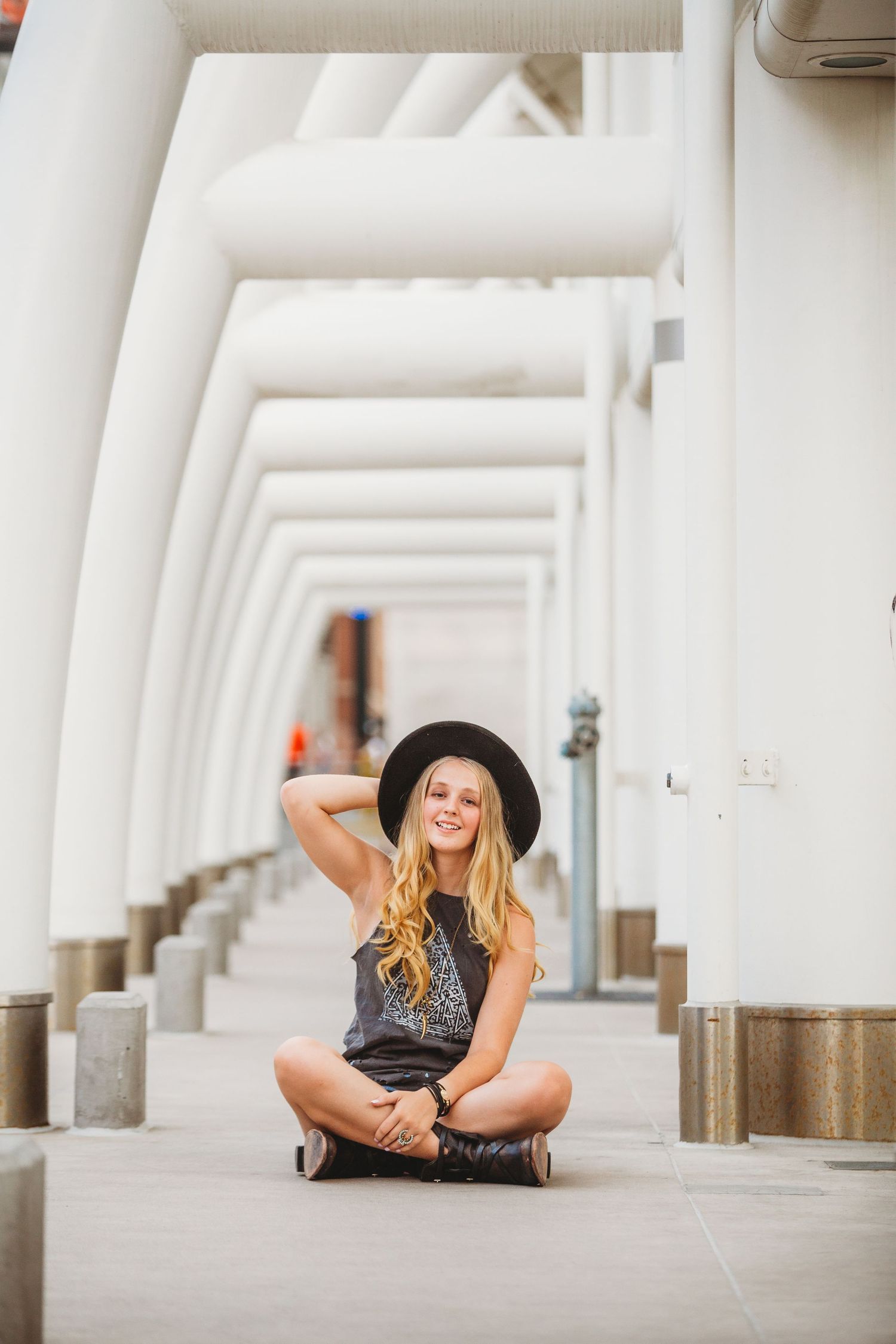 Modern architectural portrait in white colonnade with repeating geometric patterns.