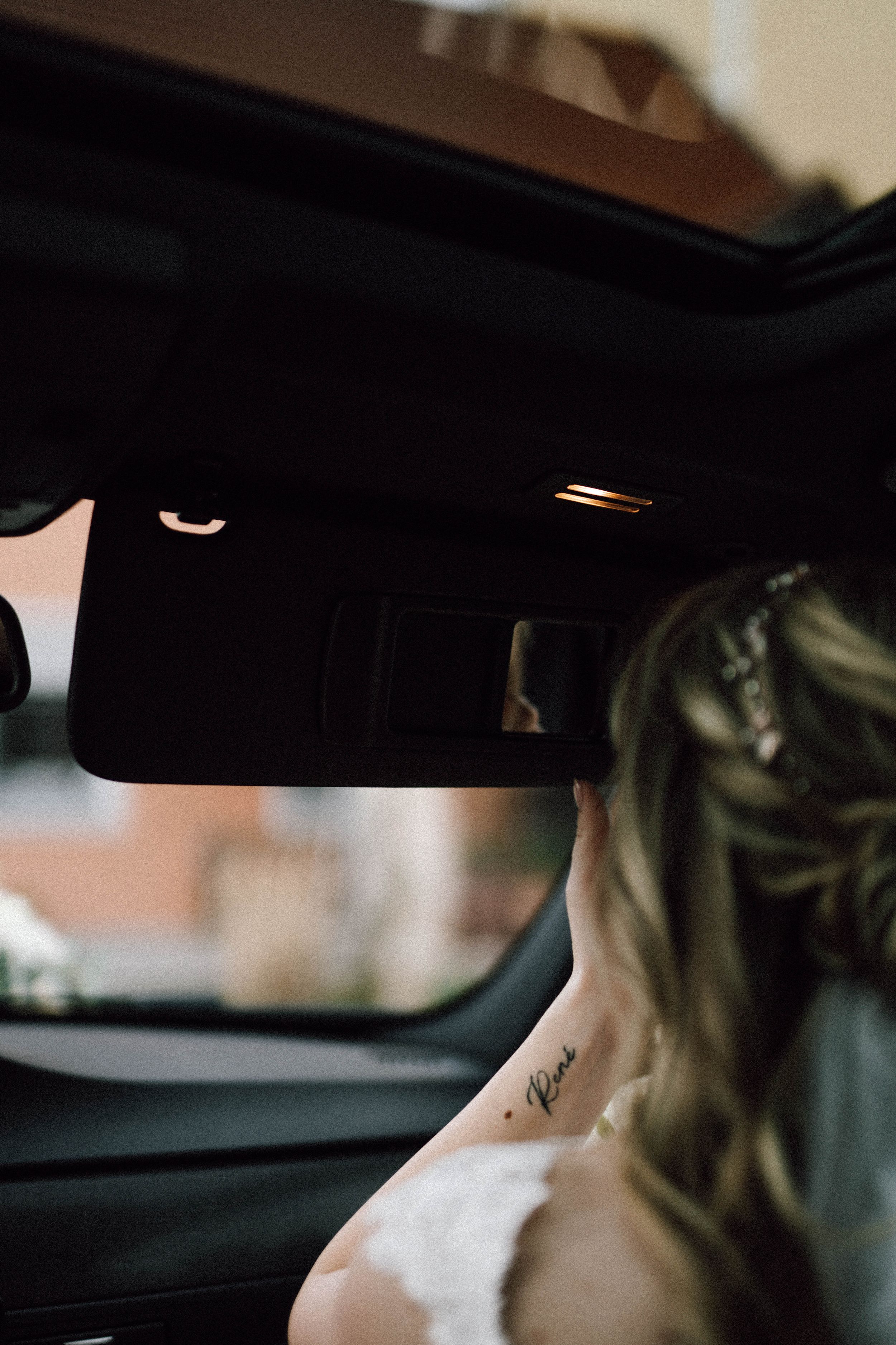 Artistic close-up shot of tattoo detail through car window.