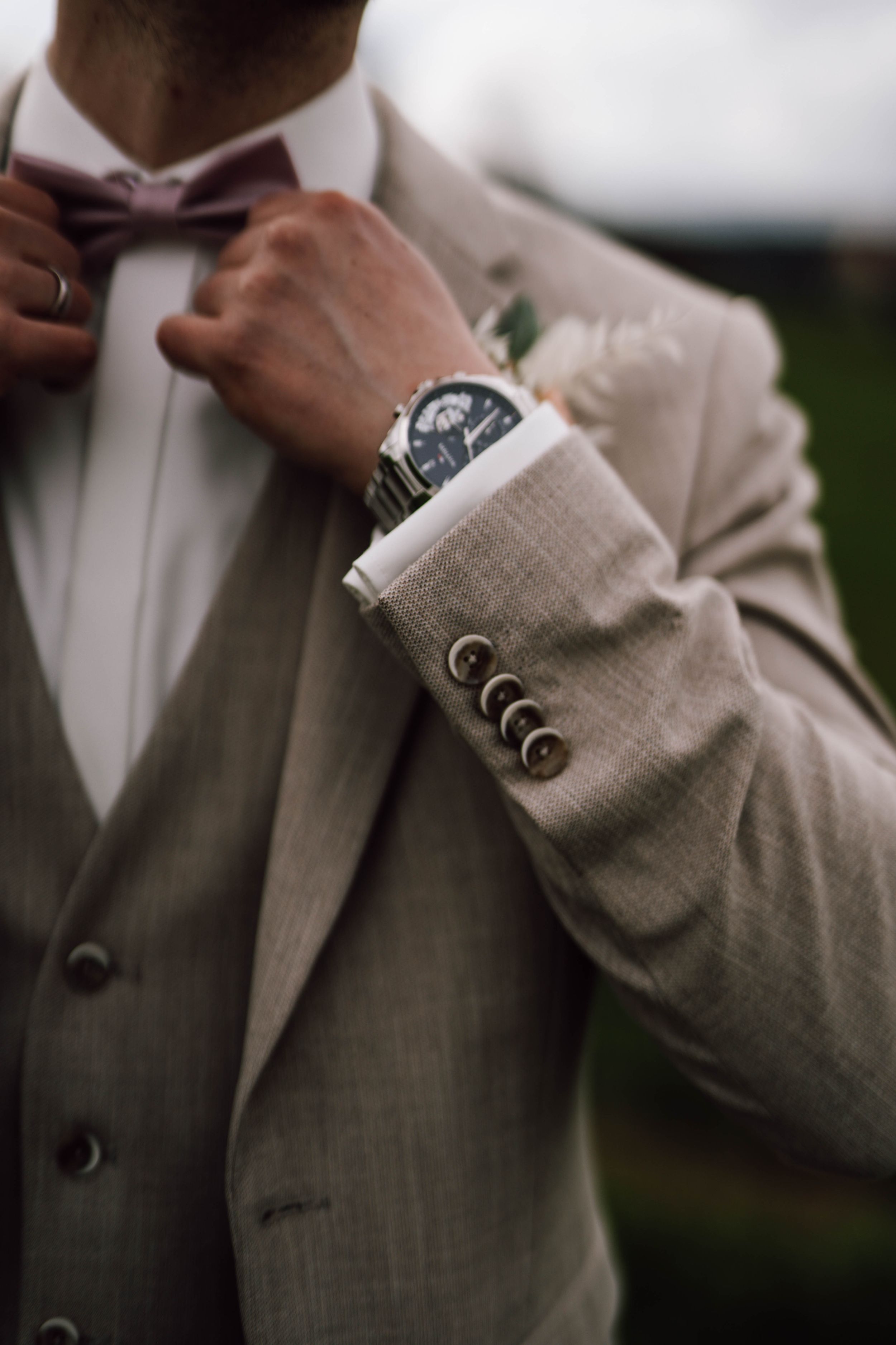 Detail shot of beige suit sleeve buttons and cuff.