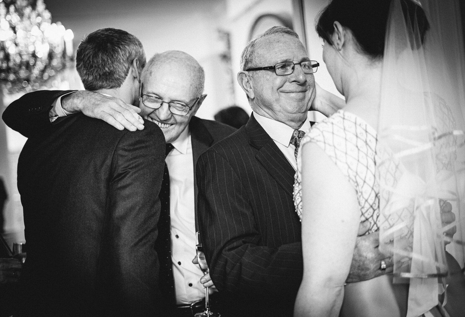 Black and white emotional moment shared between wedding guests during reception.