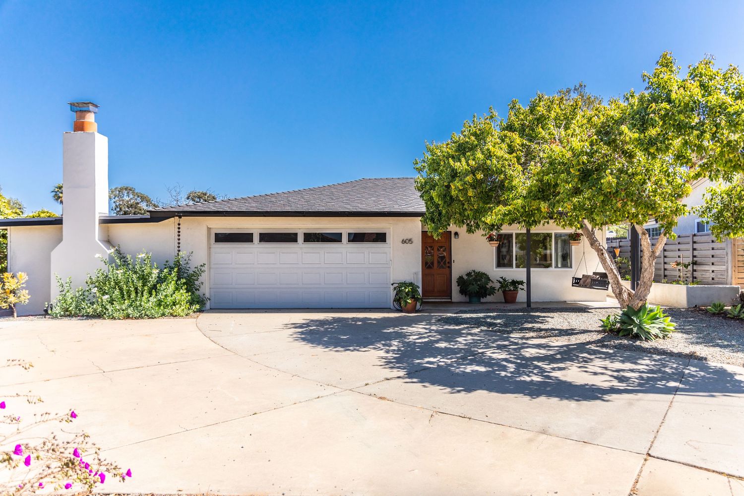 Modern ranch style home with two car garage and landscaped front yard.