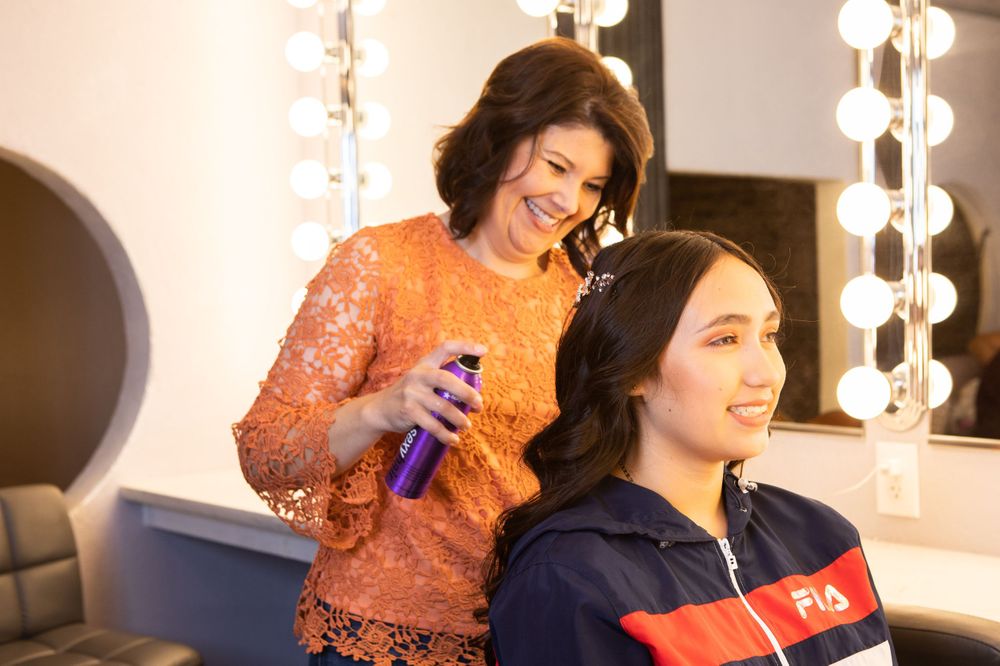 Styling session in progress at a vanity mirror with professional lighting.