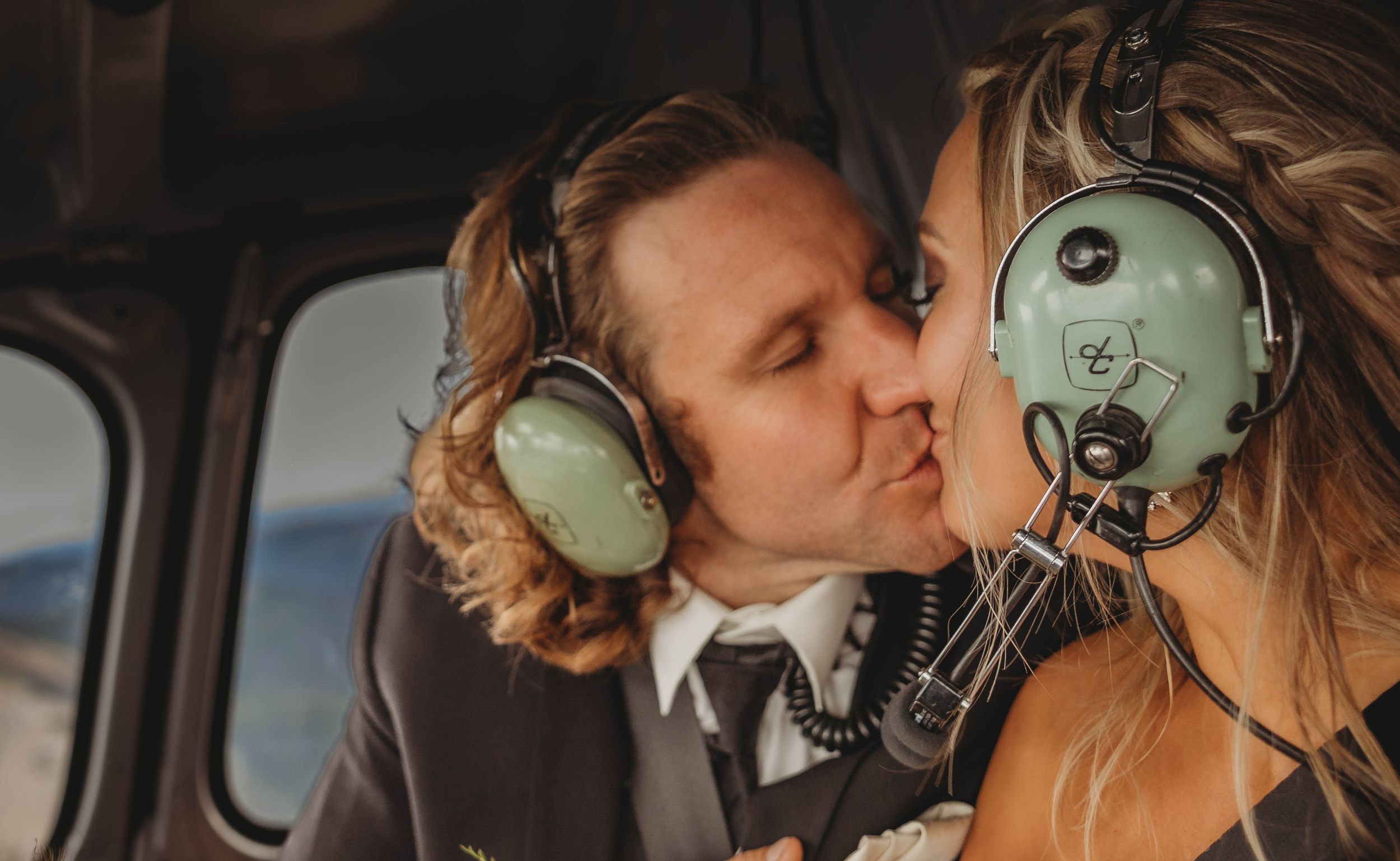 A romantic moment between couple wearing aviation headsets inside a small aircraft.