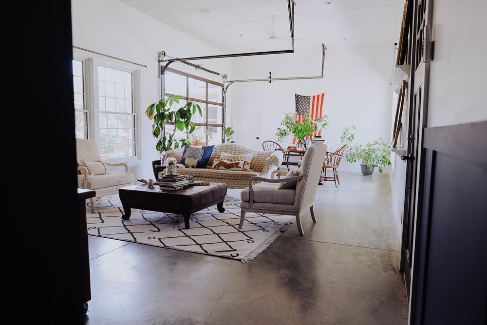 Modern living room with white walls, geometric rug, and comfortable seating arrangement.
