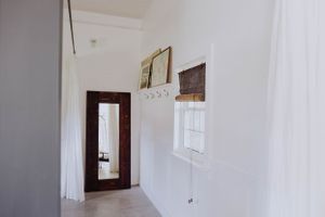 Bright white hallway interior with minimal decor and natural lighting.