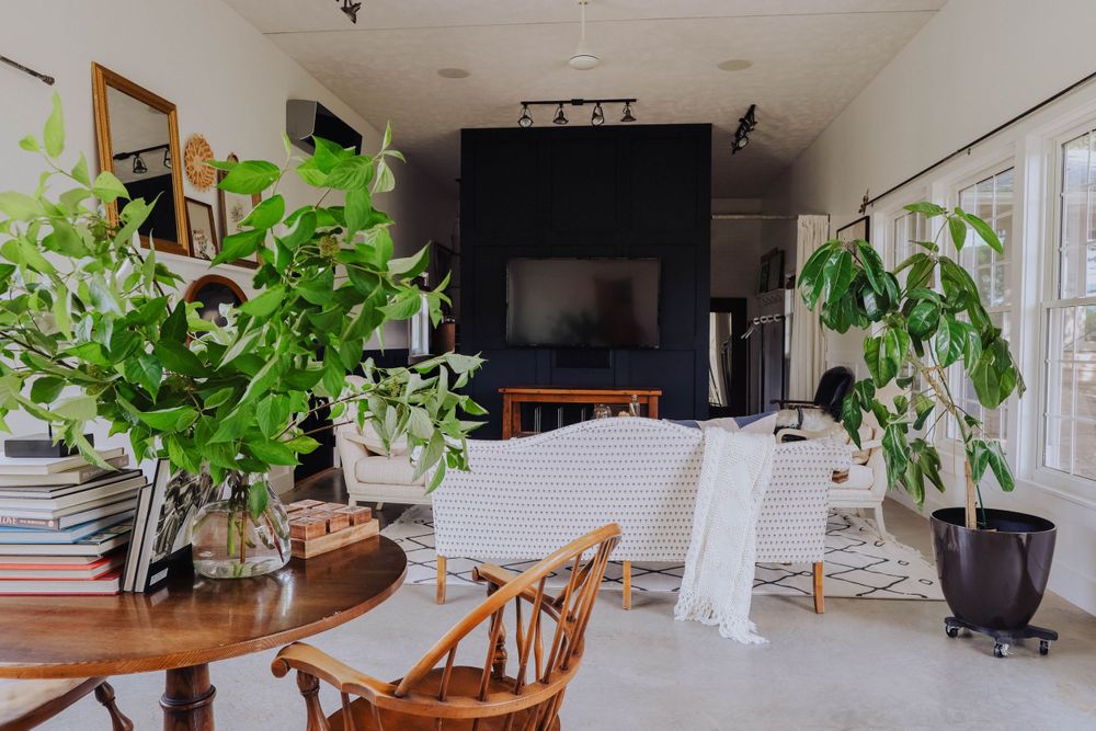 Bright minimalist room with white furniture and green plants creating a serene atmosphere.