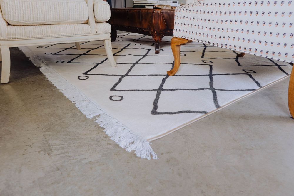 Geometric black and white area rug anchoring a contemporary living room space.
