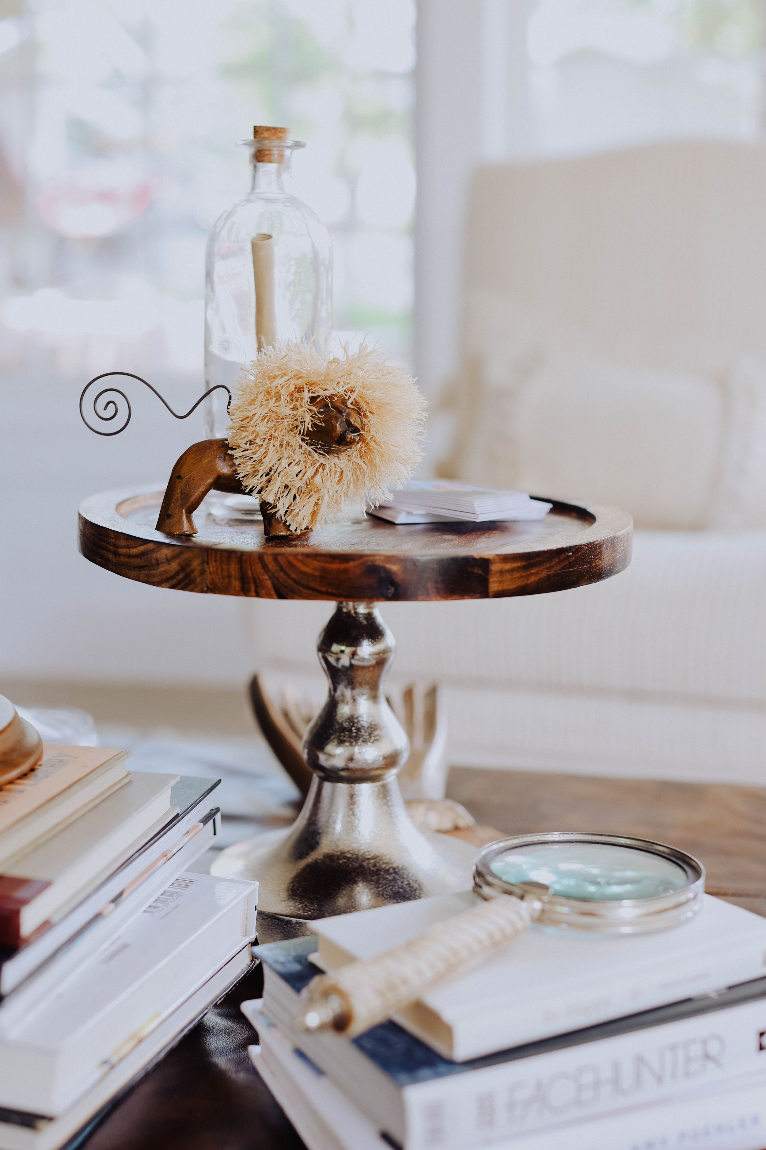Decorative vignette on wooden table featuring books and vintage-style accessories.