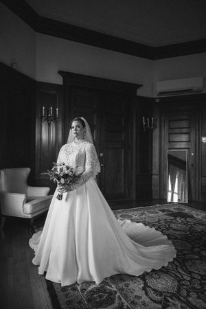 Black and white photos of a bride in an elegant white wedding dress posing in a traditional room setting.