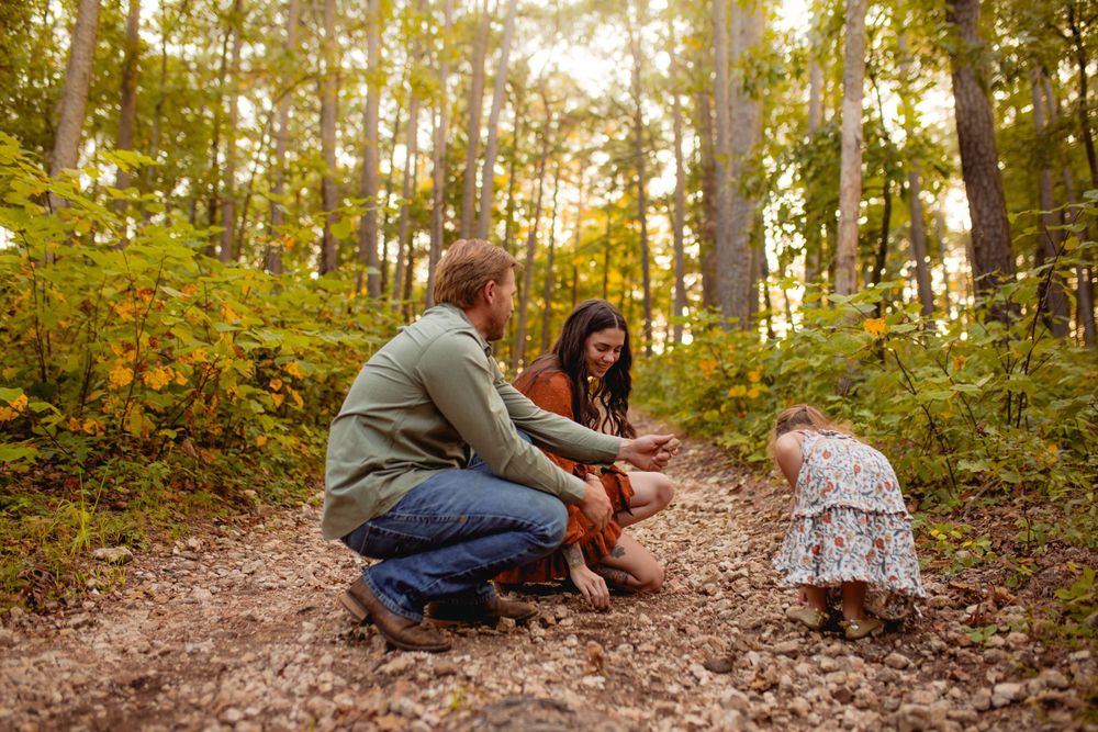 Family enjoying the beauty of Mark Twain National Forest Pines, with the little girl proudly holding the rock she discovered.