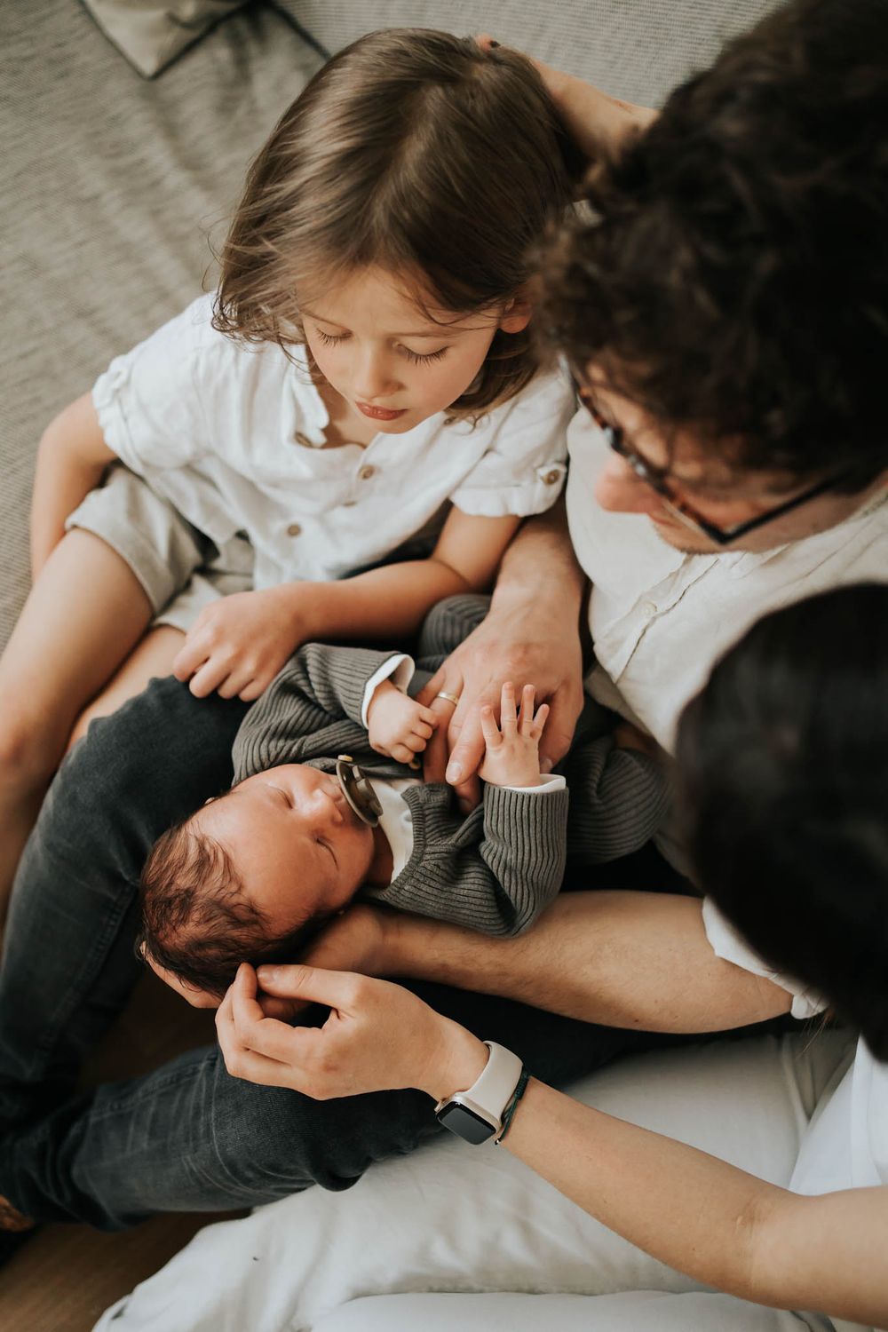mama, tata i brat wpatrzeni w noworodka - fotograf Kraków