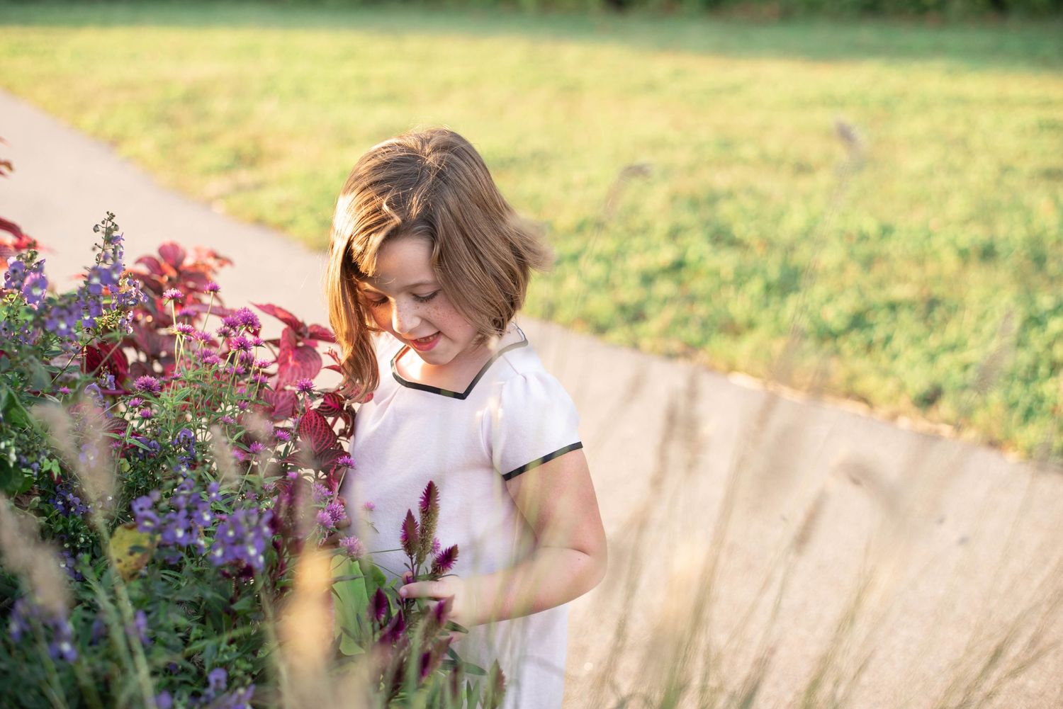 Little girl smiles at the flowers she sees.