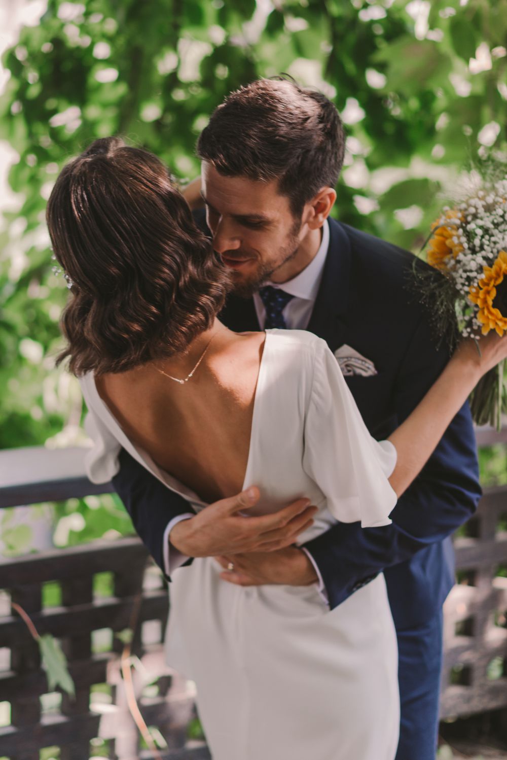 Intimate wedding couple embrace captured in romantic sequence outdoors.