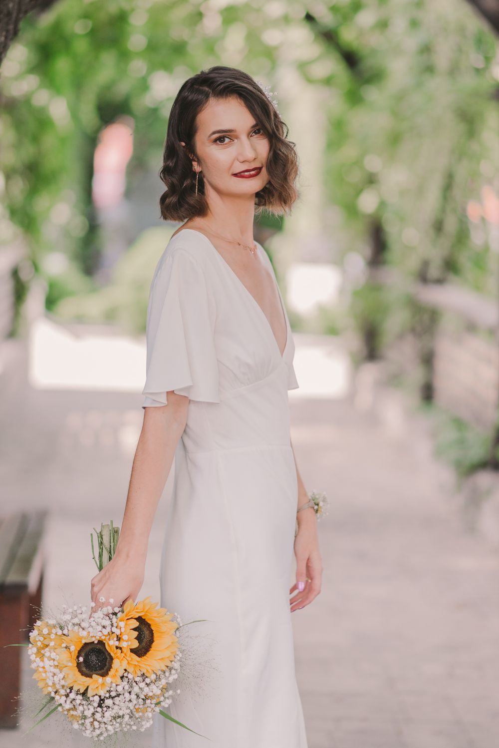 A romantic garden wedding scene with white dress and sunflower bouquet details.