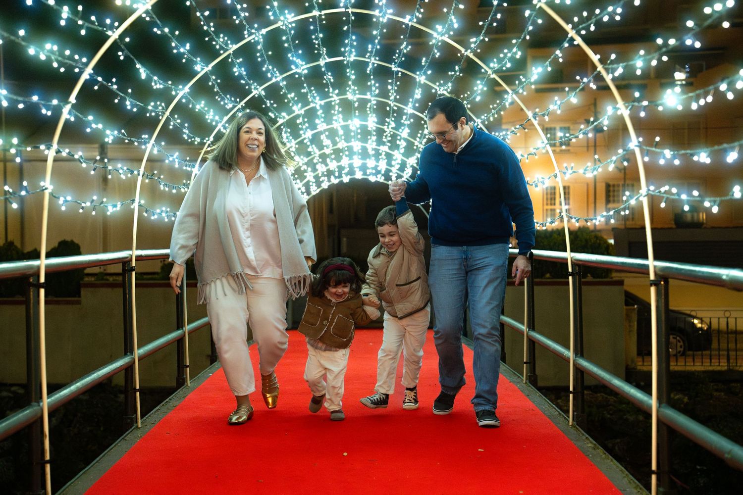 Illuminated tunnel walkway with string lights creating magical archway effect.