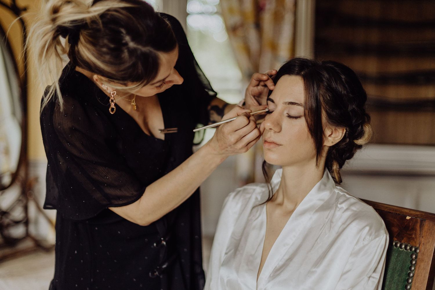 Préparatifs de mariage capturés en lumière naturelle, gestes tendres et détails élégants.