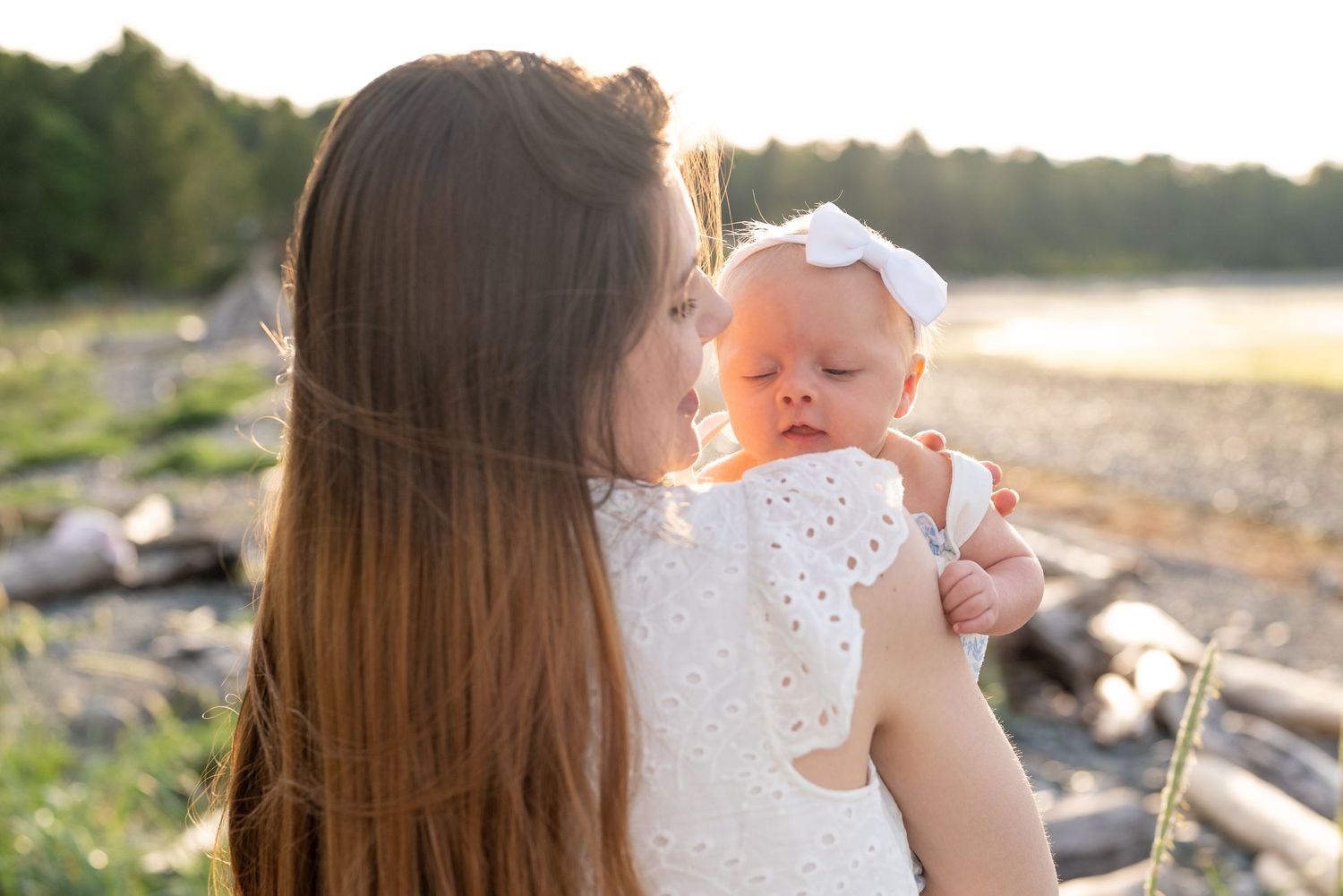 Photoshoot of a young mother holding her baby at the beach.