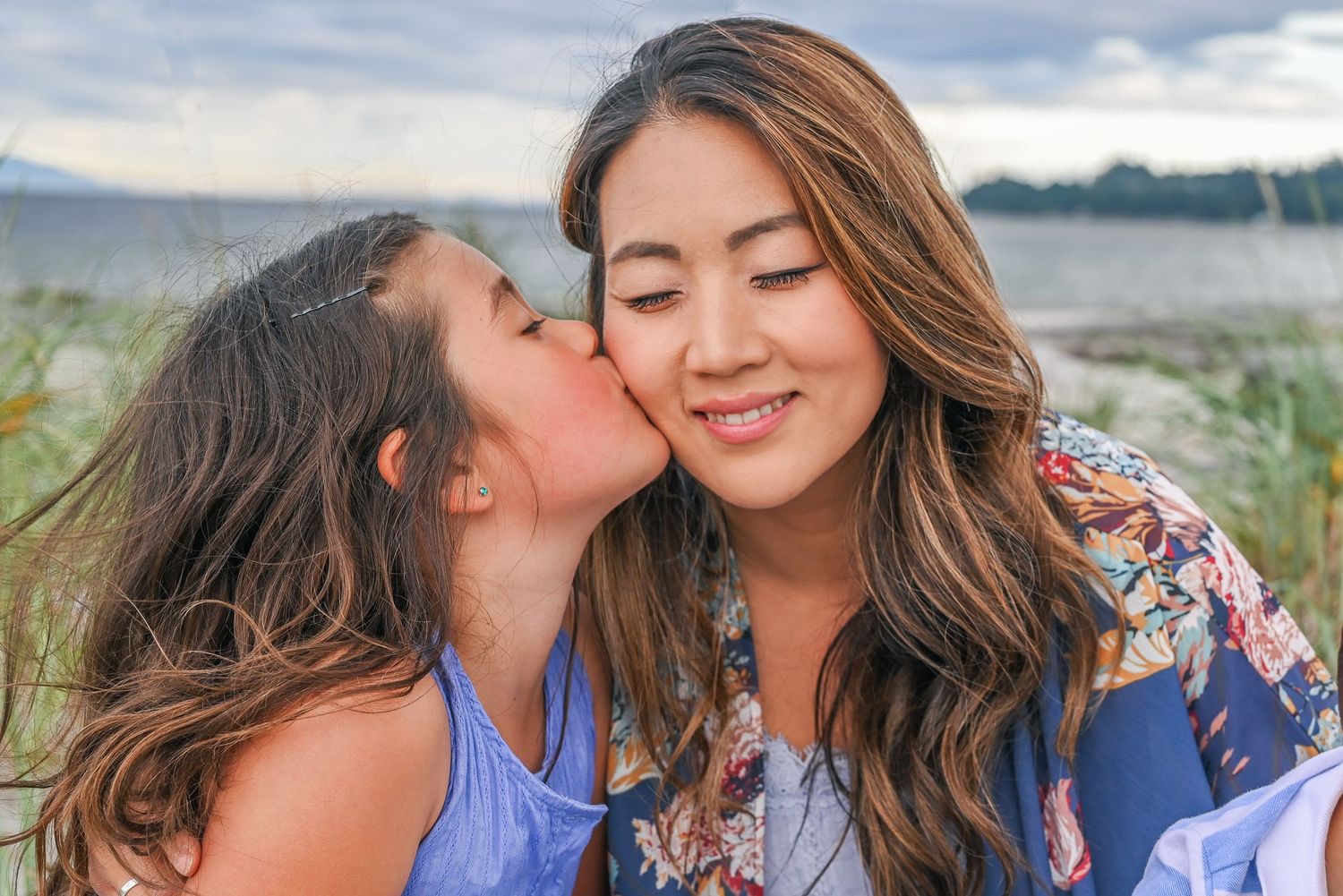 Photoshoot with young girl kissing mom.