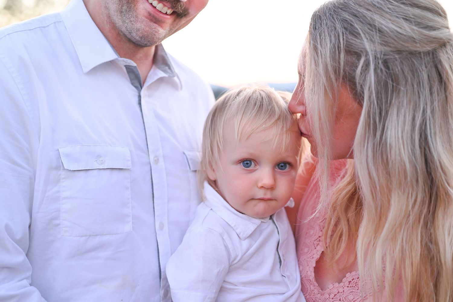 Photoshoot of couple holding toddler son.