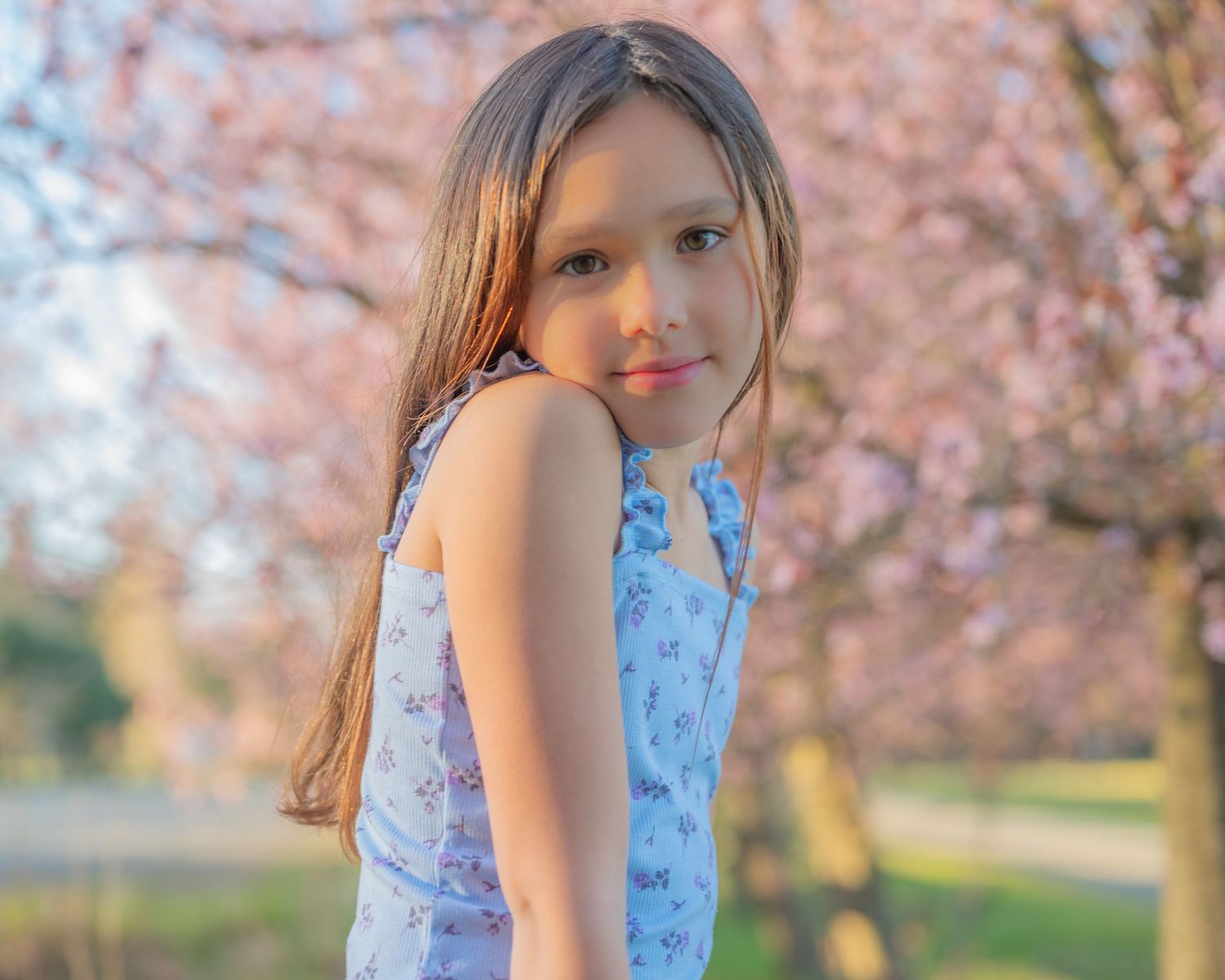 Photoshoot of young girl with cherry blossoms.