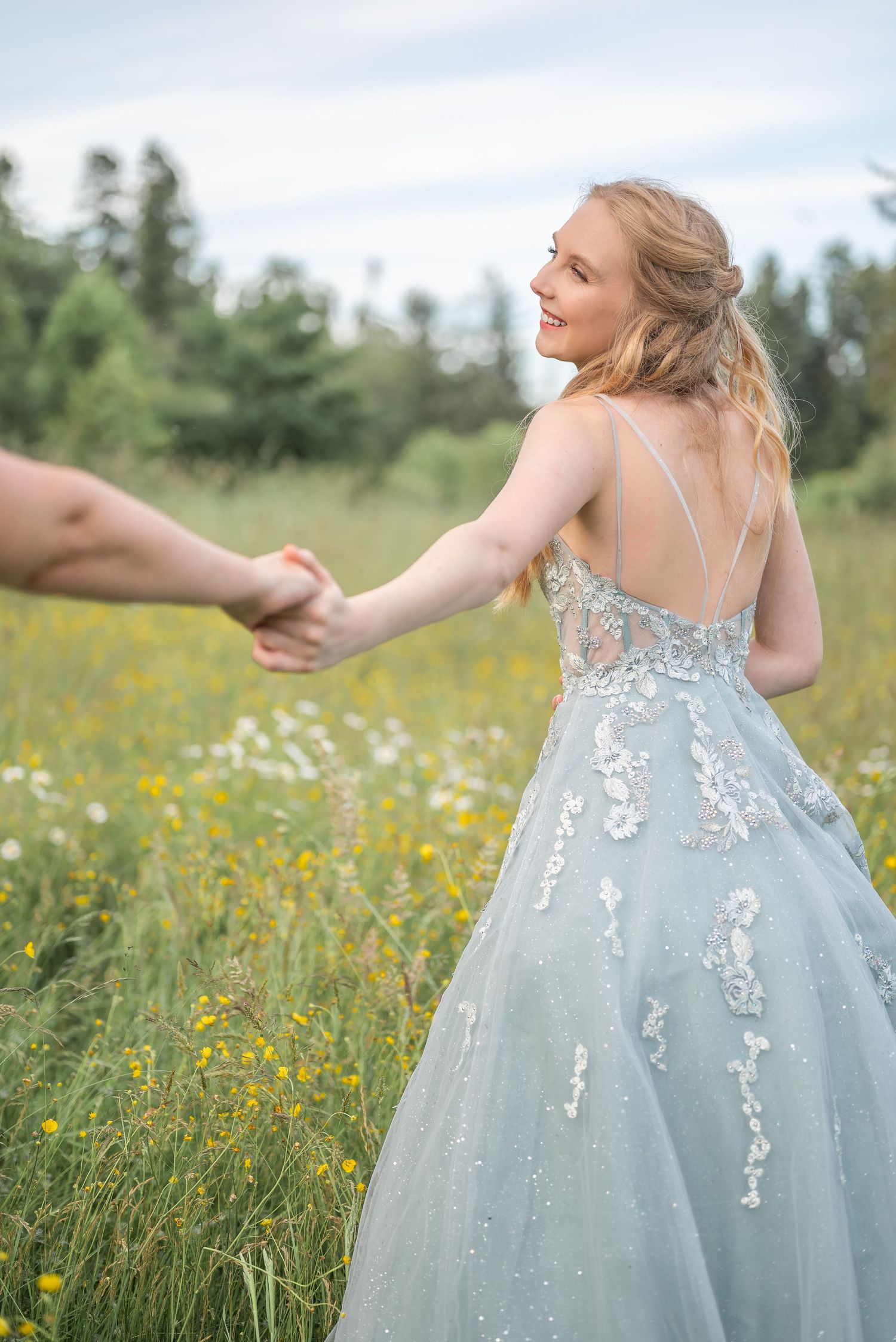 Photoshoot in a meadow of a teen in her light blue prom dress.
