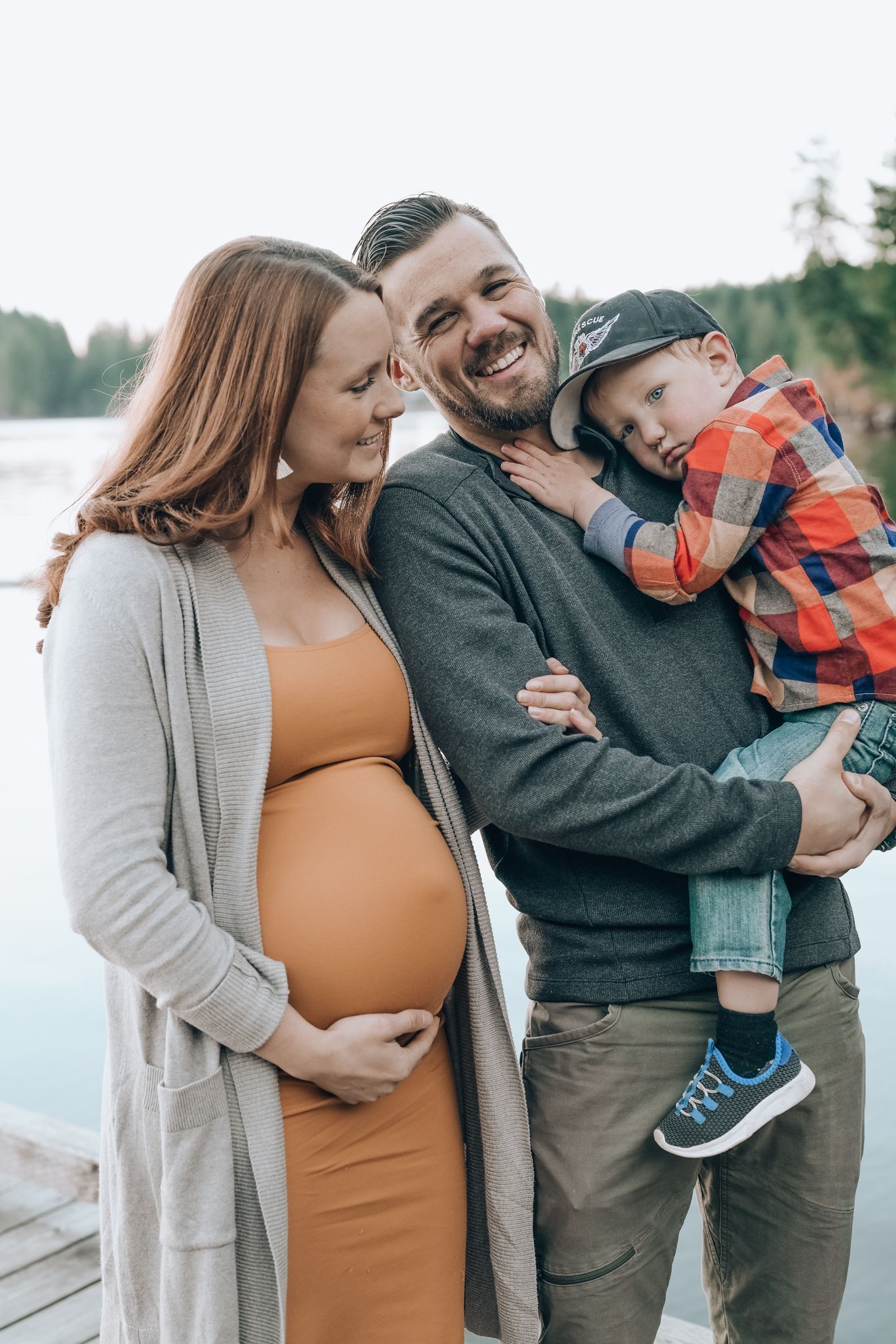 Expecting mom, with her partner and young son share a laugh.