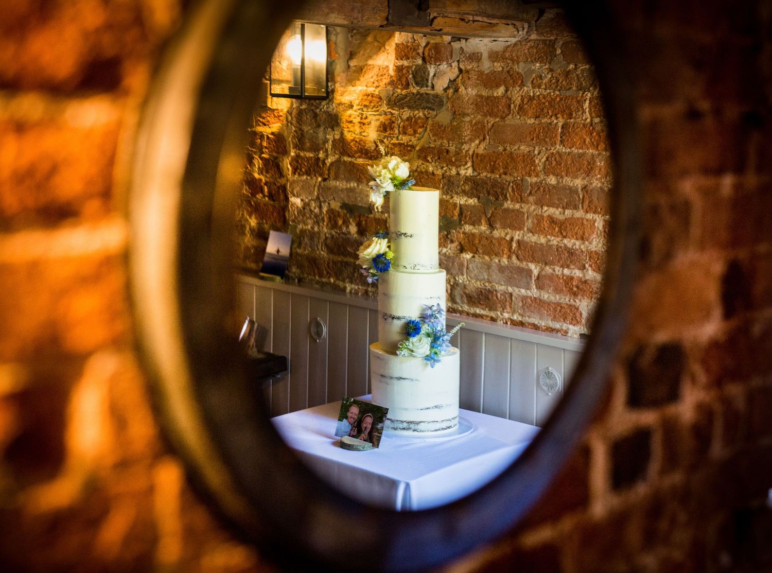 Rustic brick wall interior with warm lighting creates intimate wedding venue atmosphere.