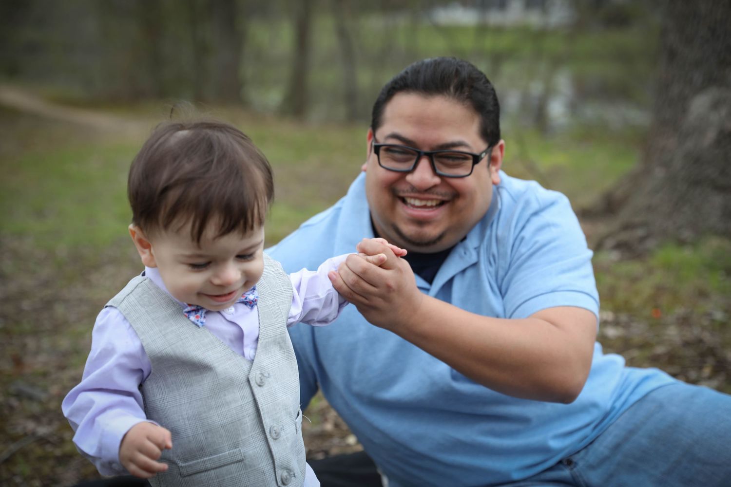 Parent and child share a joyful moment together outdoors. Family photoshoot. L. Visions Photography. father and son.
