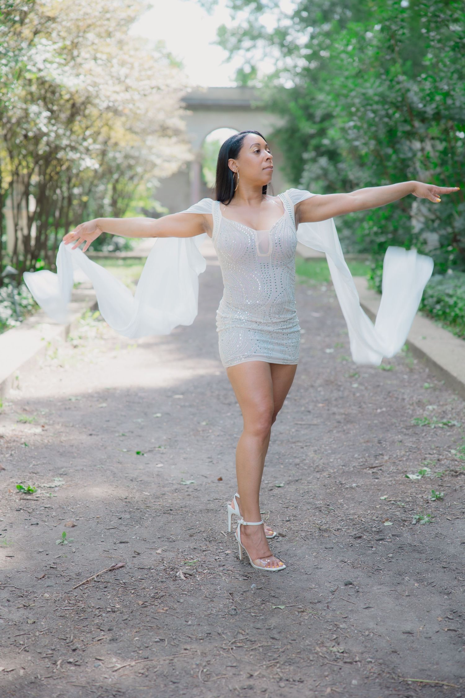 Woman in white dress dances with flowing fabric on outdoor trail. Lifestyle photoshoot. L. Visions Photography