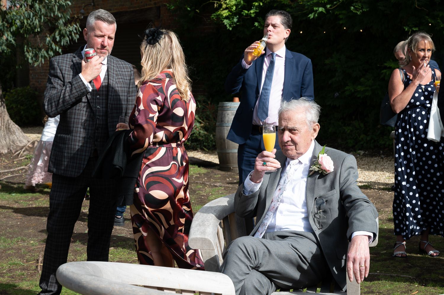 Wedding guests enjoying drinks and socializing outdoors during reception.