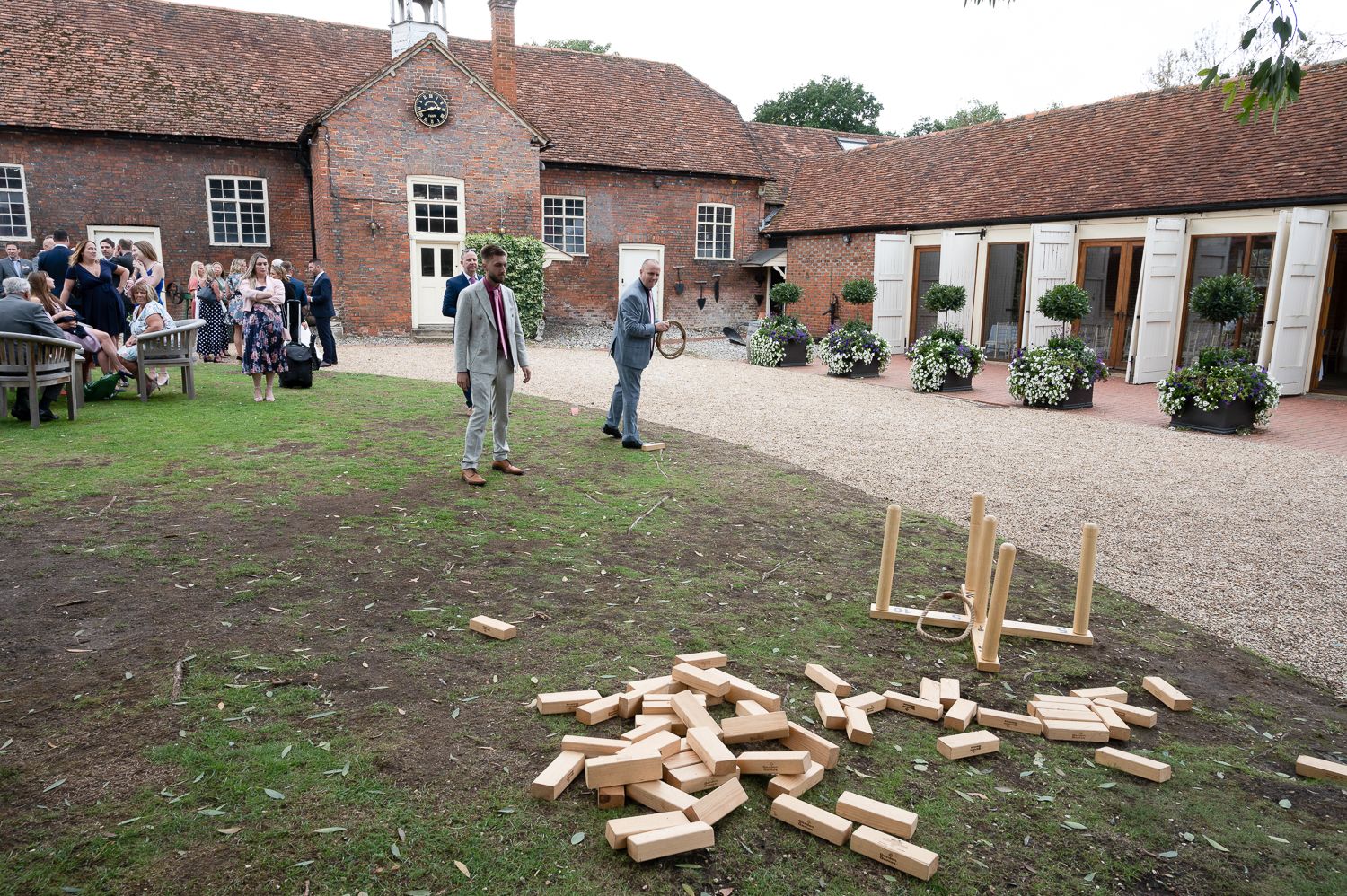 Giant Jenga game set up in courtyard during outdoor wedding reception.