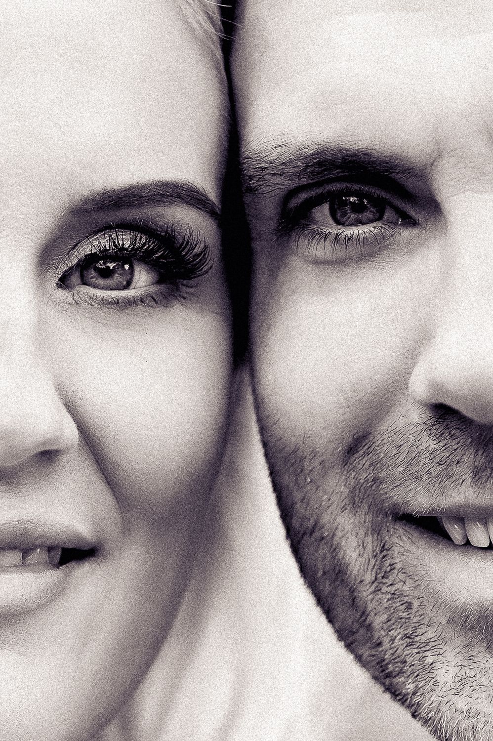 Close-up black and white portrait showing half faces of a couple sharing an intimate moment.