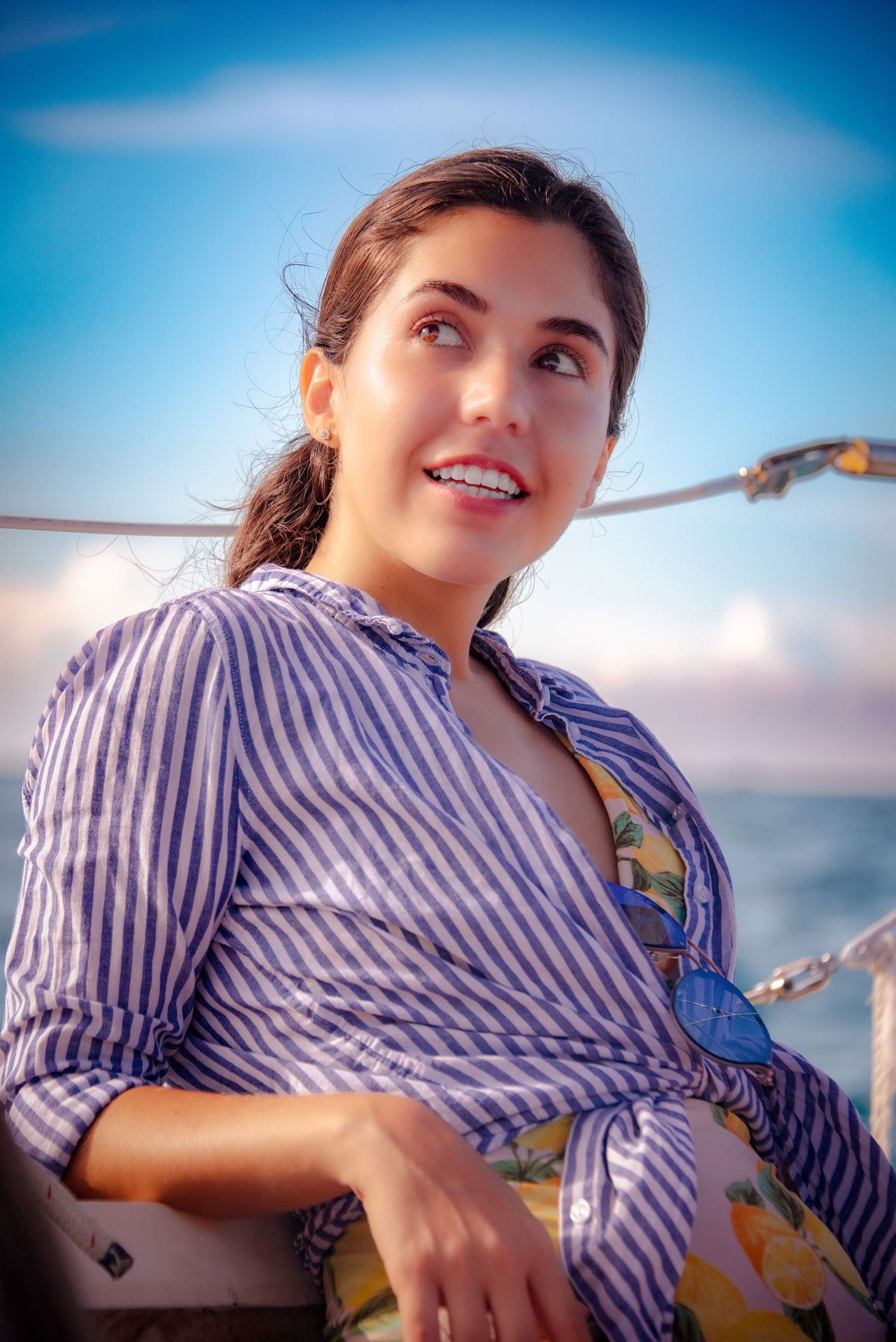 A candid portrait shot at sea featuring blue skies and striped clothing.