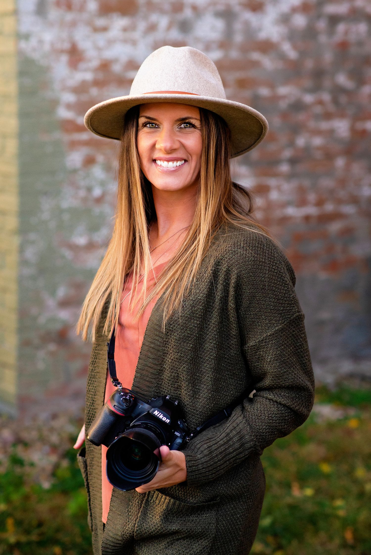 alt="A professional photographer is holding her camera for a portrait"