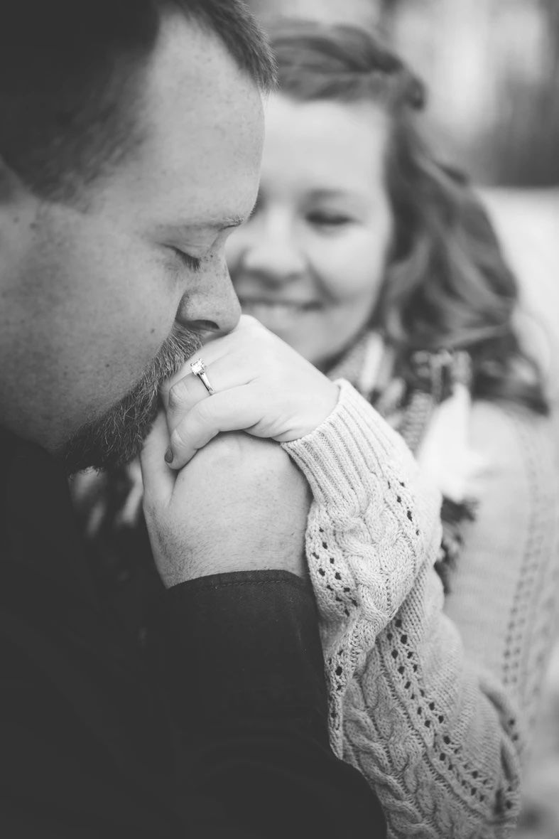 A black and white close-up photo captures an intimate moment between a couple.